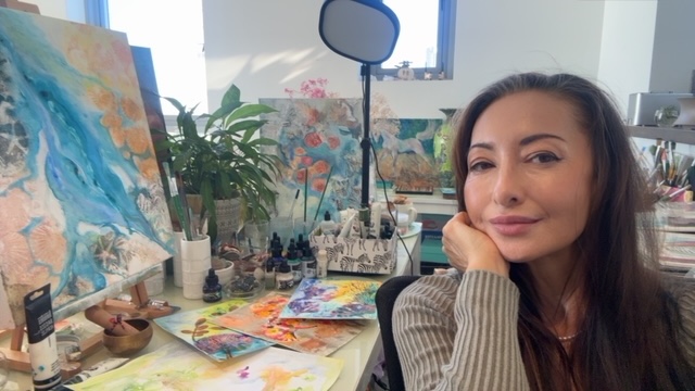 Michele McLeod in her studio surrounded by paintings, plants and her painting tools