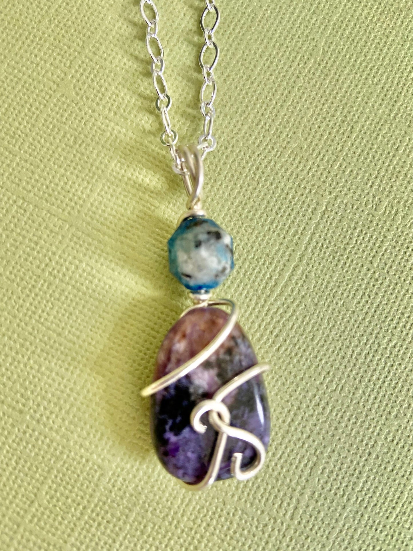 Two beautiful gemstones K2 and Lepidolite intertwined with sterling silver to form a lovely pendant.